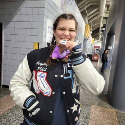 Trueblood bites her medal at state.